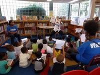 Summer Reading Outreach Specialist Rich Torrance reads to a group of kids at West Oak Lane Library